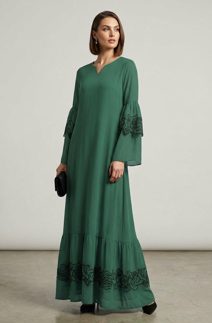 Woman wearing a green dress with lace details on a plain background