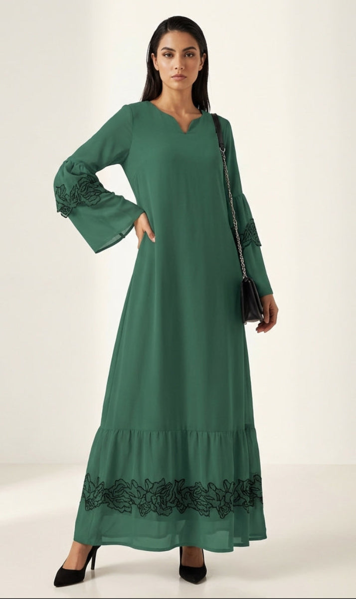 Woman wearing a green dress with lace details on a white background