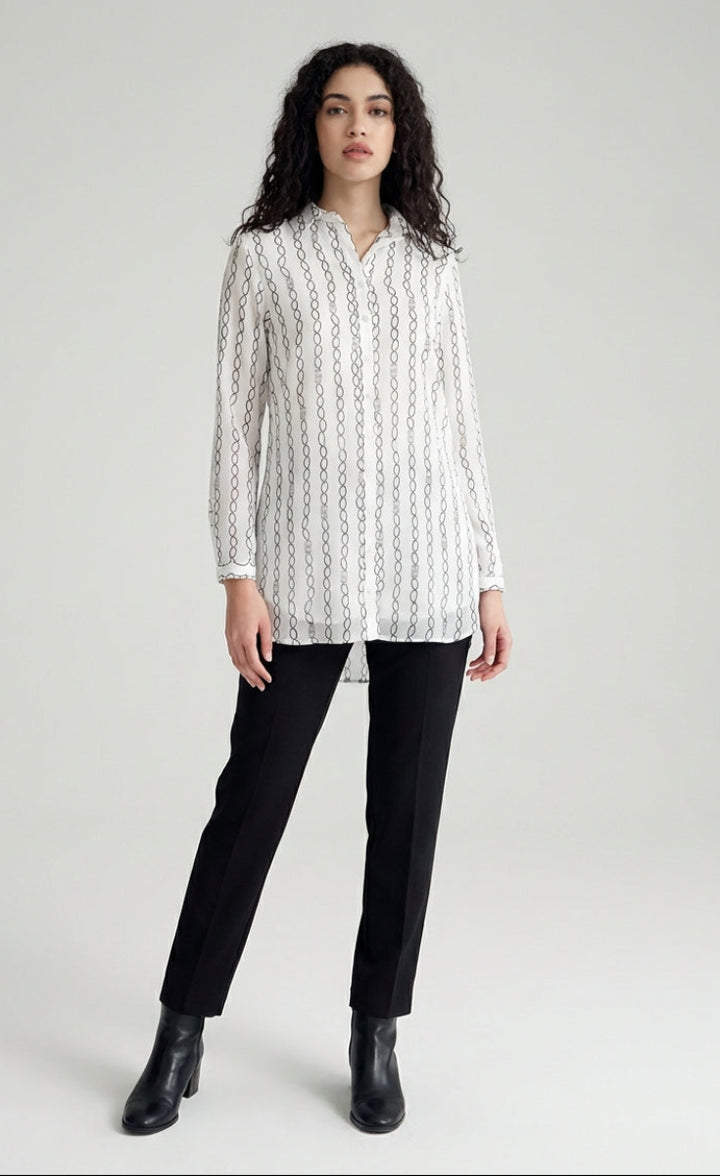 Woman wearing a white patterned shirt and black pants on a white background