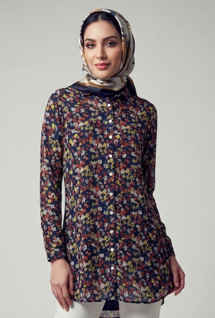 Woman wearing a floral blouse and white pants on a gray background