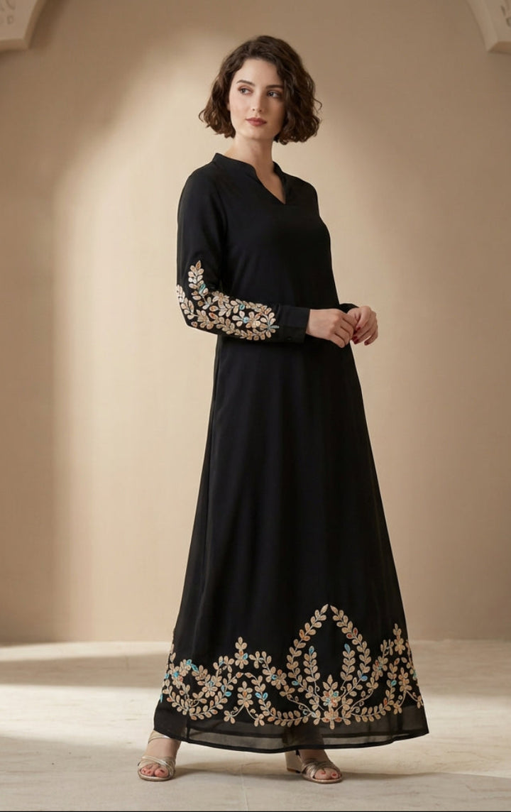 Woman wearing a black dress with gold embroidery in an ornate room.