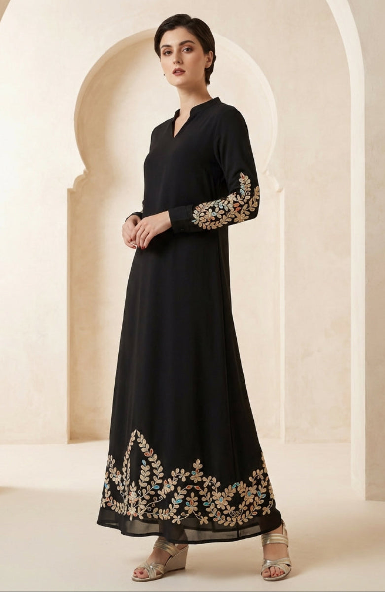Woman wearing a black dress with gold embroidery in an archway setting