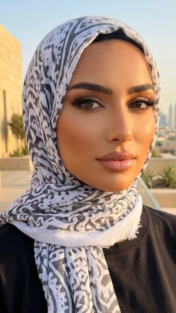 Woman wearing a patterned hijab with a cityscape in the background