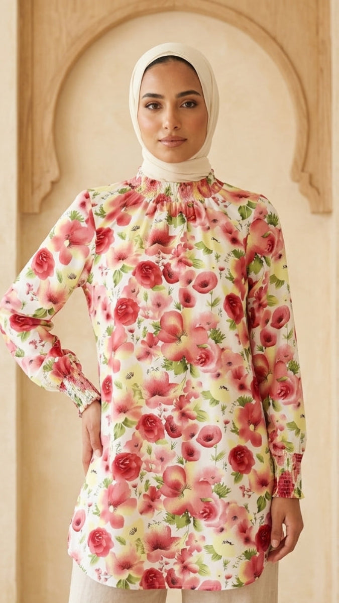 Woman wearing a floral blouse and hijab in a beige interior setting