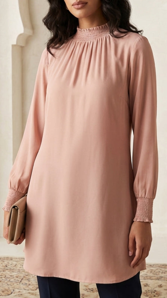 Woman wearing a pink dress in an elegant interior setting