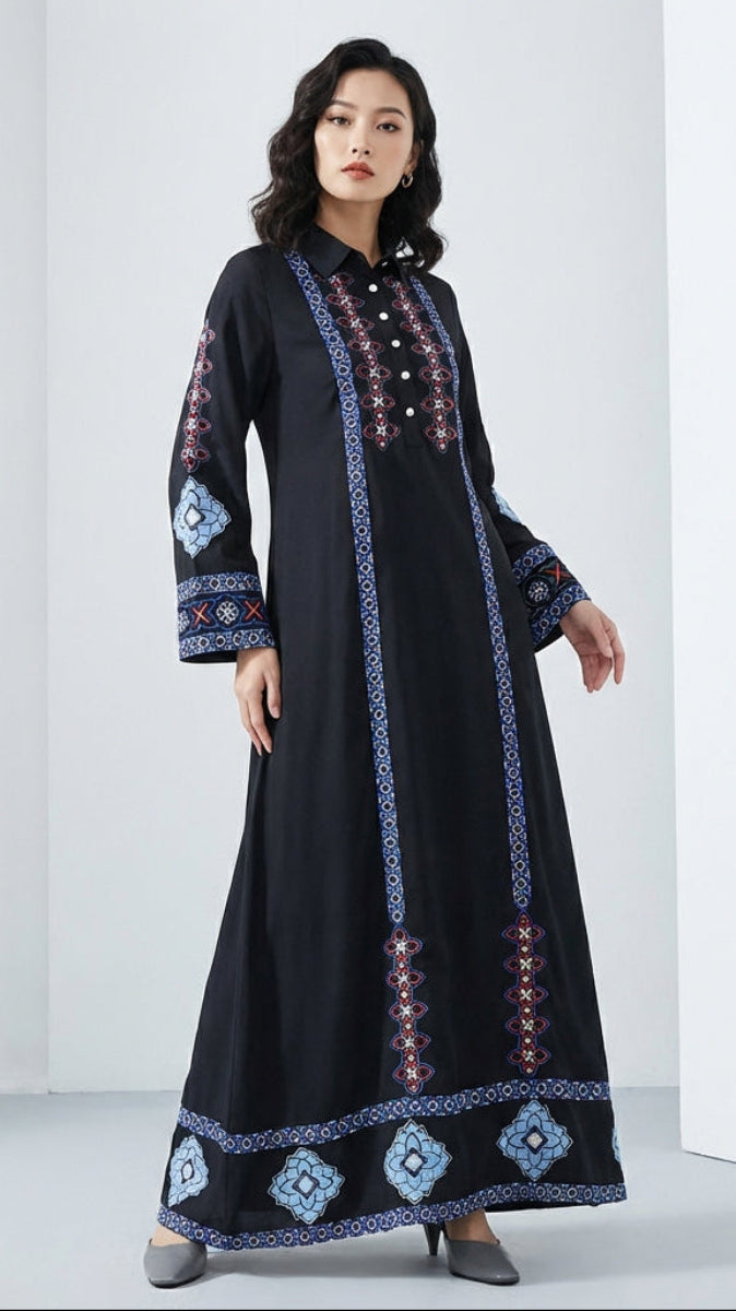 Woman wearing a black dress with blue and red embroidery on a white background