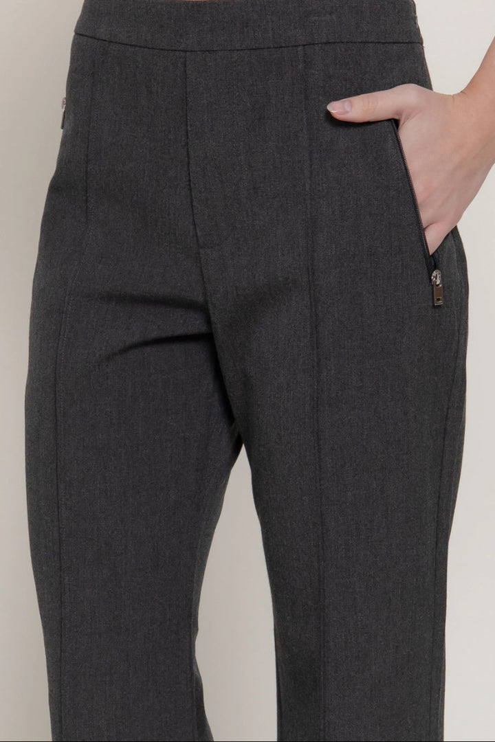Dark gray pants worn by a person on a plain background