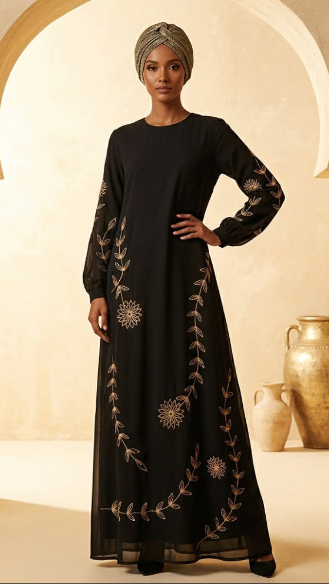 Woman in a black dress with embroidery standing in a decorative setting with pots.