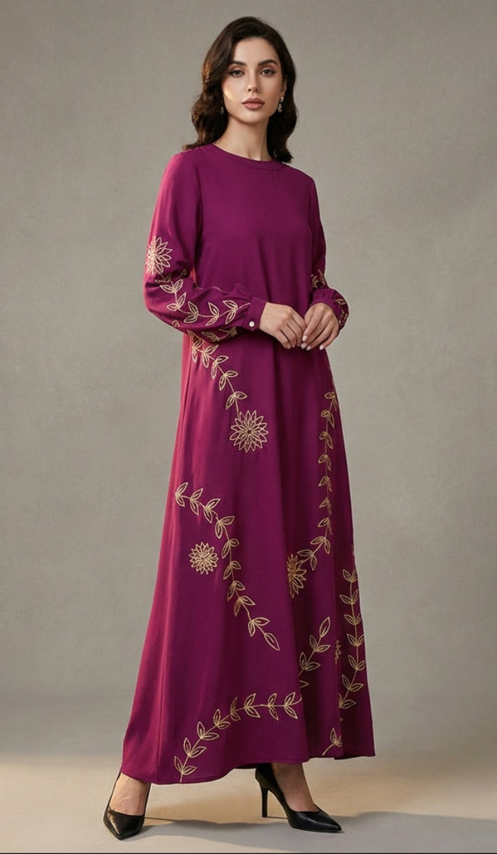 Woman wearing a long, embroidered purple dress against a neutral background