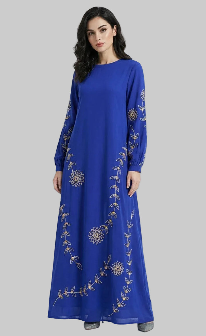 Woman wearing a blue dress with gold embroidery on a white background