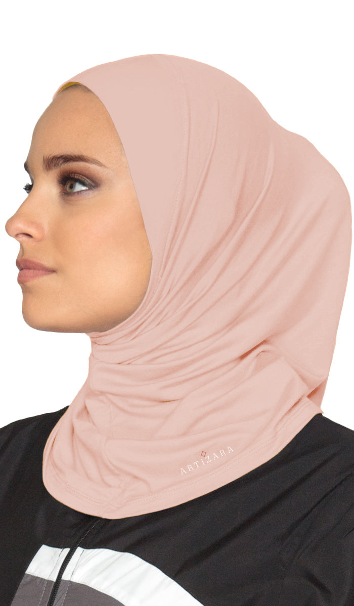 Woman wearing a light pink hijab with a visible brand logo on a white background