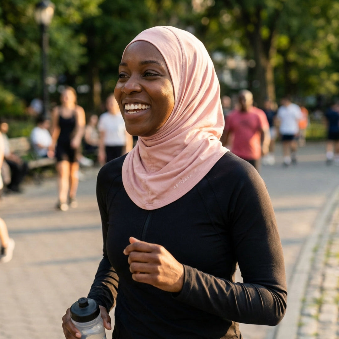 Woman in a hijab exercising outdoors with a water bottle