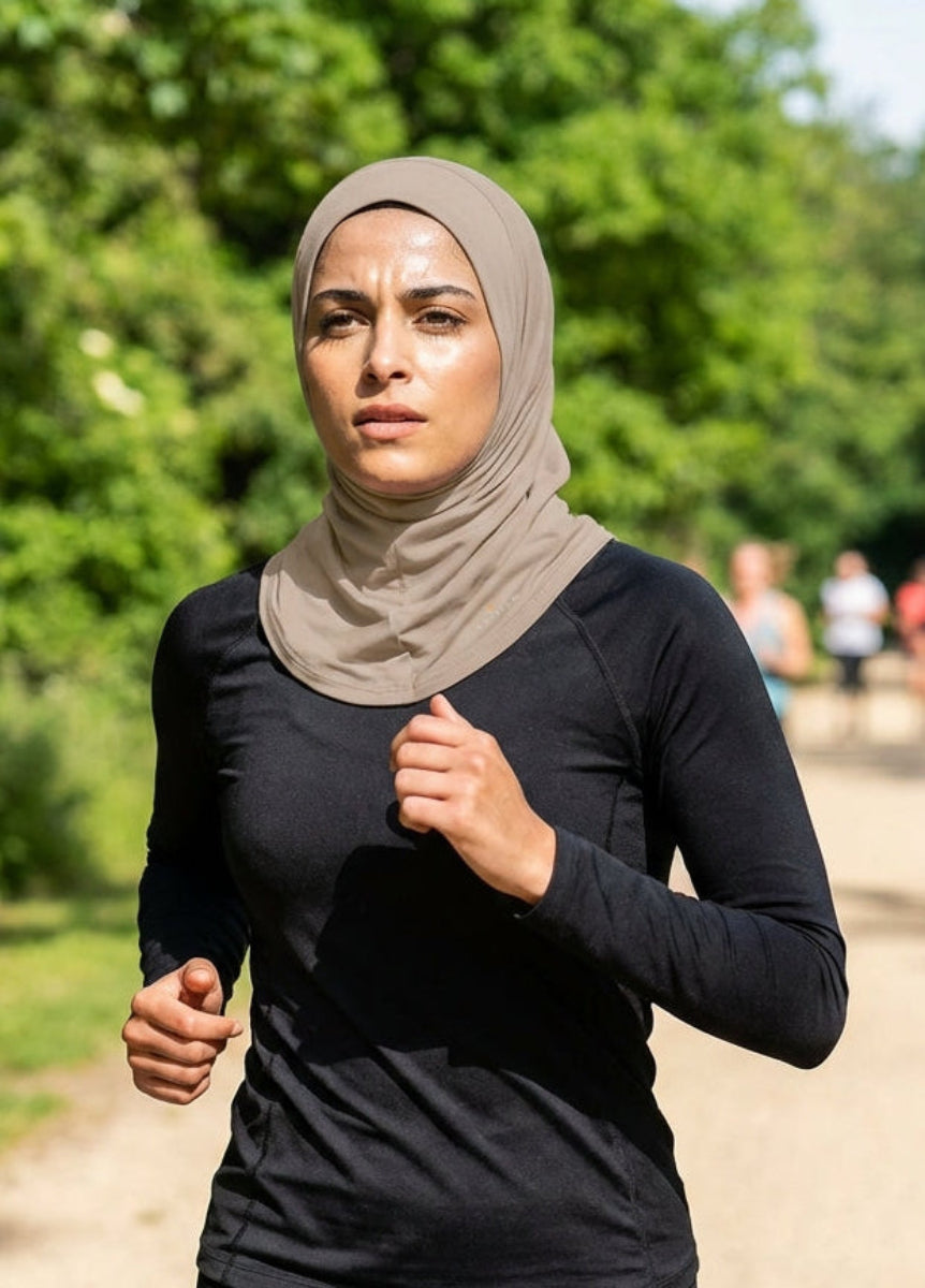 Woman running outdoors on a path with trees and other runners in the background