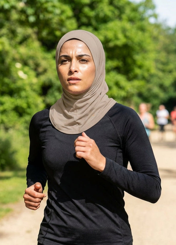 Woman running outdoors on a path with trees and other runners in the background