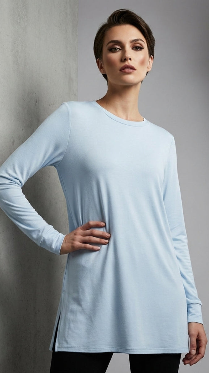 Woman wearing a light blue long-sleeve dress against a gray background