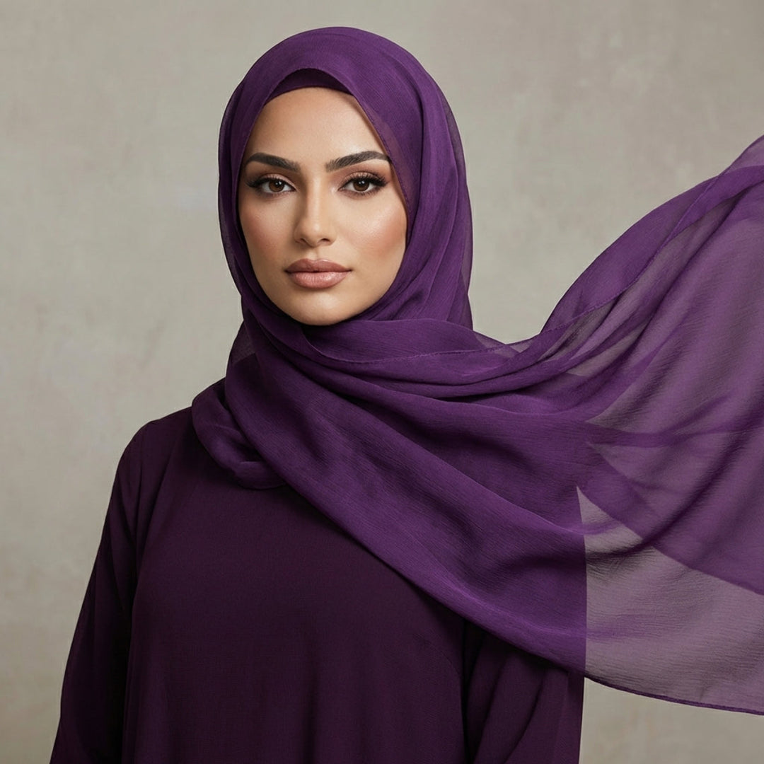 Woman wearing a purple hijab against a neutral background