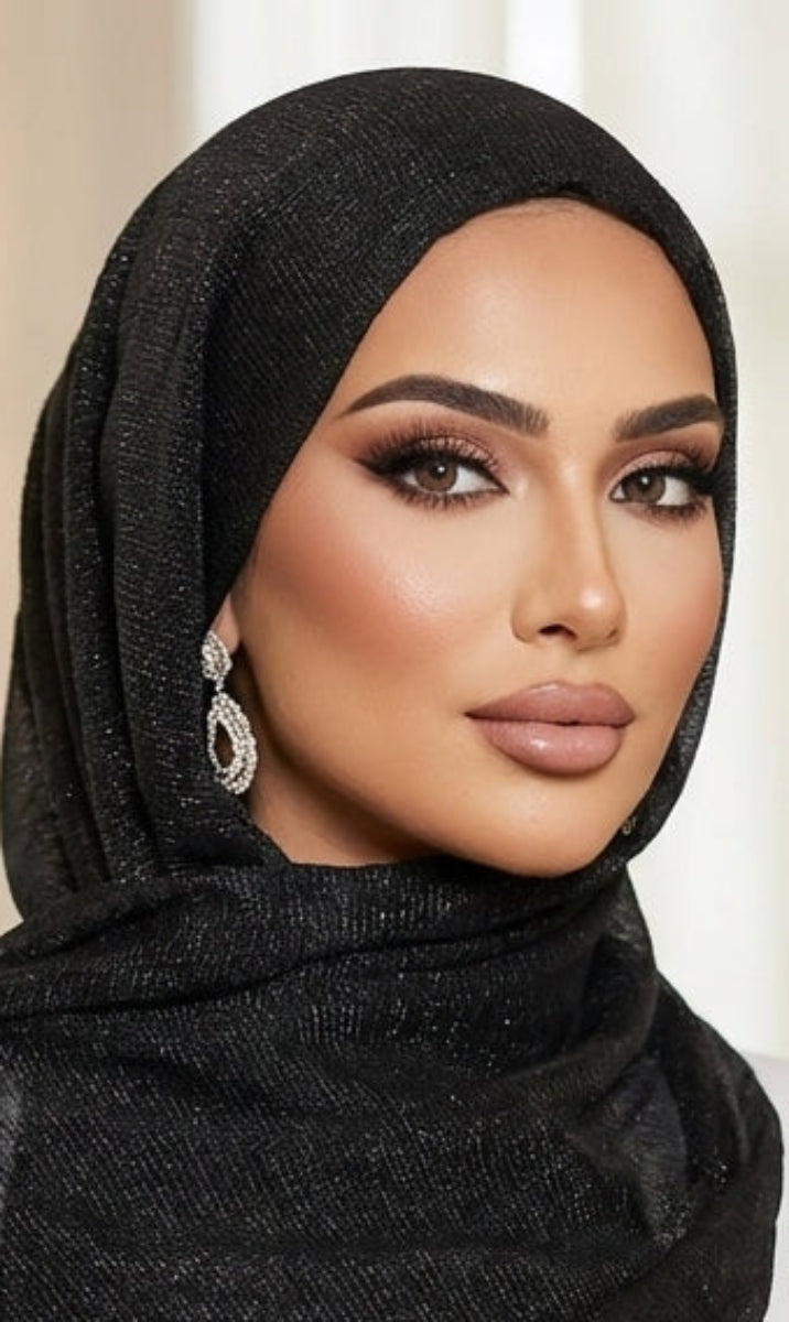 Woman wearing a black hijab and scarf in an elegant indoor setting