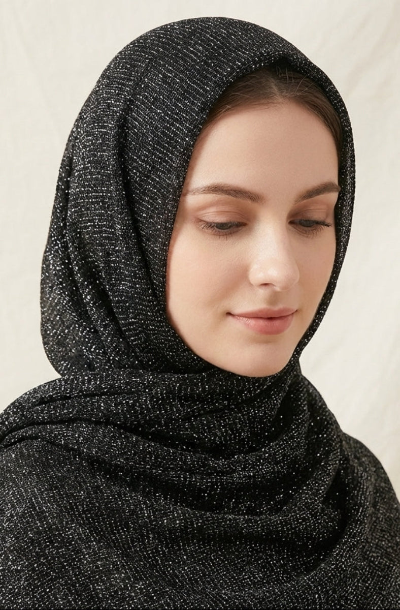 Woman wearing a black hijab against a beige background