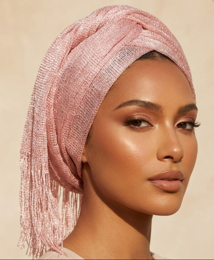 Woman wearing a pink headscarf against a beige archway background