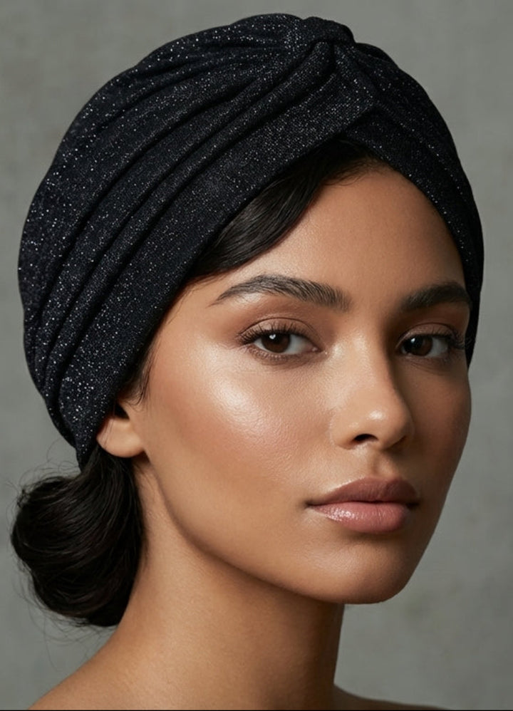 Woman wearing a black textured headscarf against a gray background