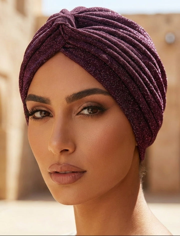 Woman wearing a purple headscarf in an arched stone building setting