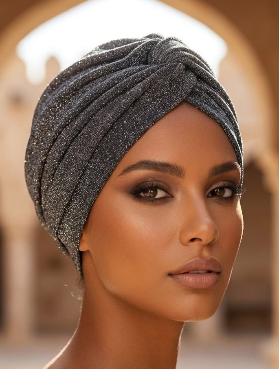 Woman wearing a sparkling headscarf in an arched architectural setting