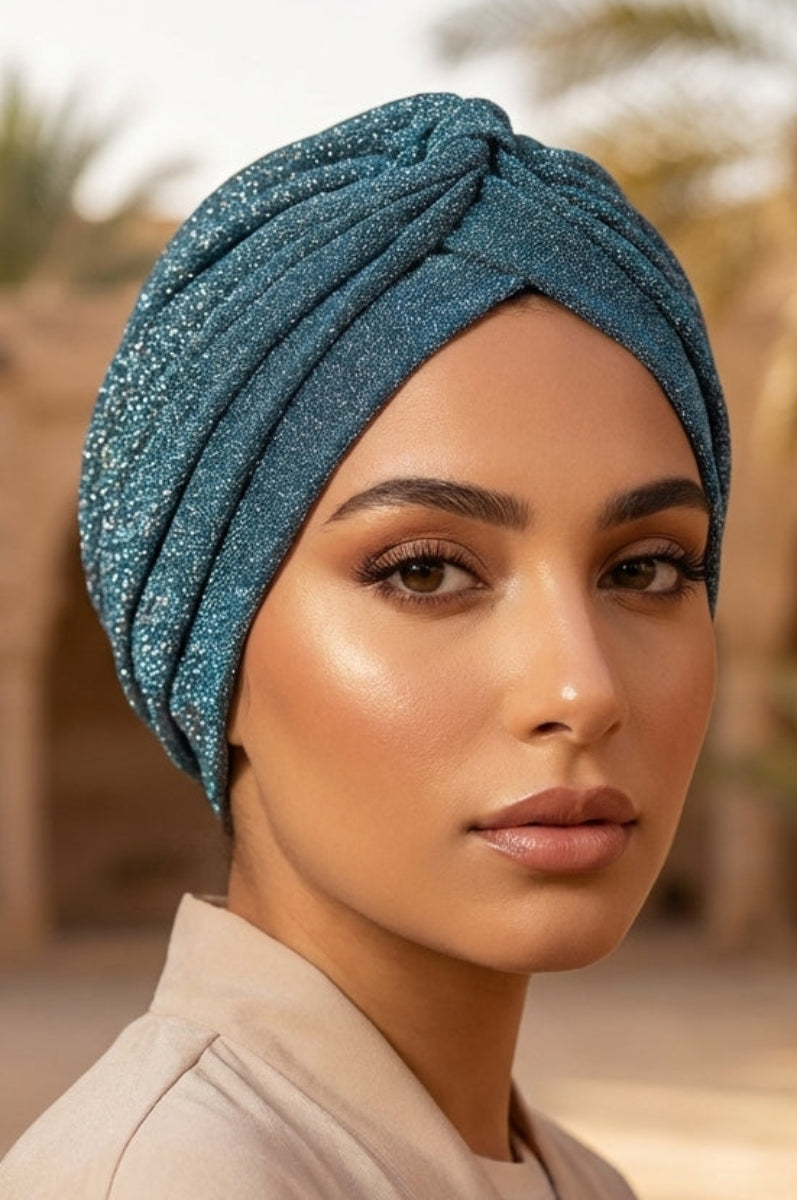 Woman wearing a blue turban in an arched architectural setting