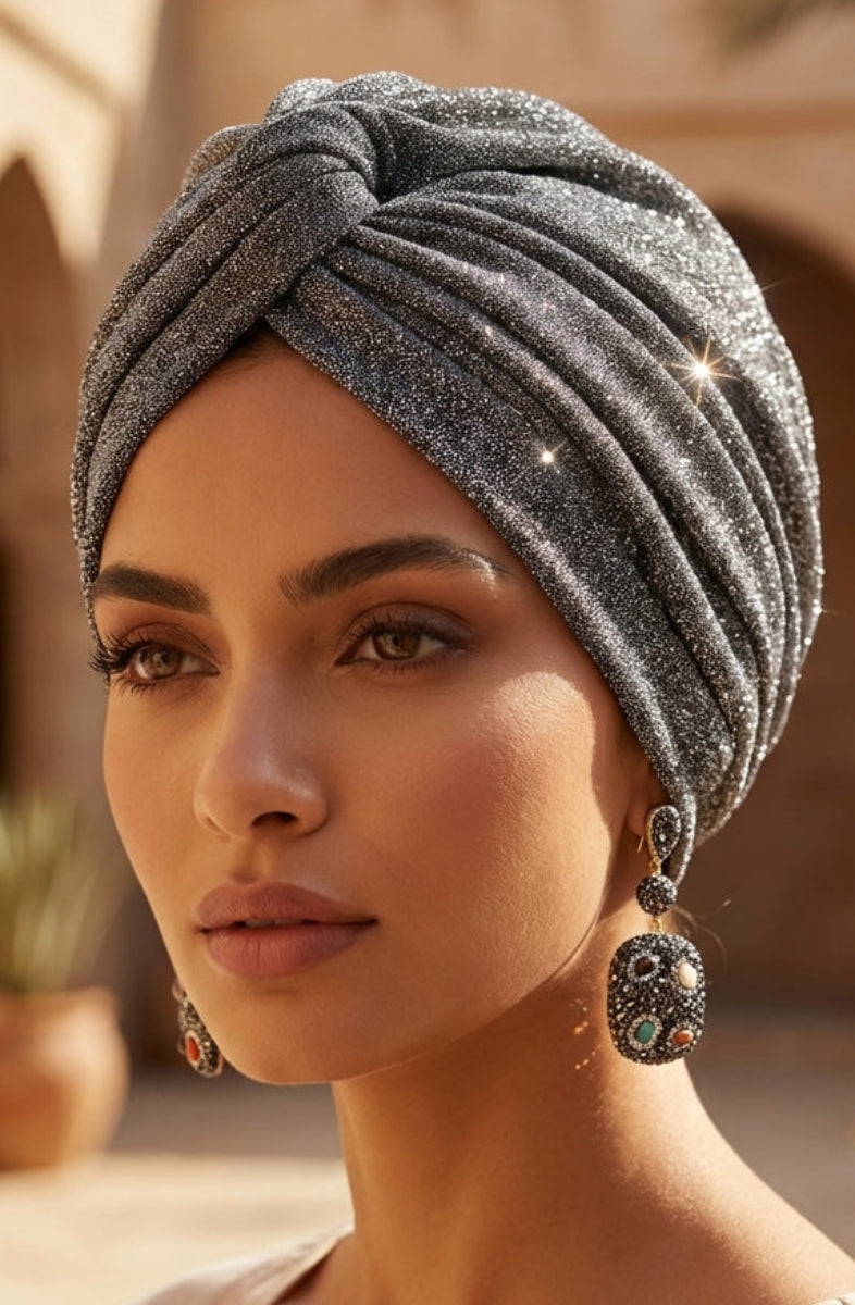 Woman wearing a gray turban with a warm, outdoor setting in the background