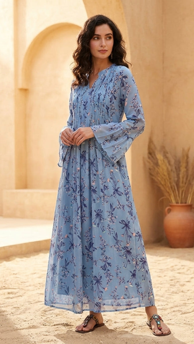 Woman in a blue floral dress standing in a sunlit, arched stone corridor.