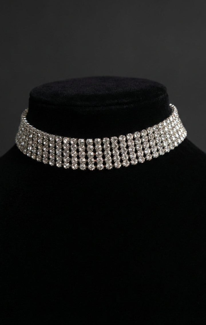 Silver choker necklace on a black mannequin against a dark background