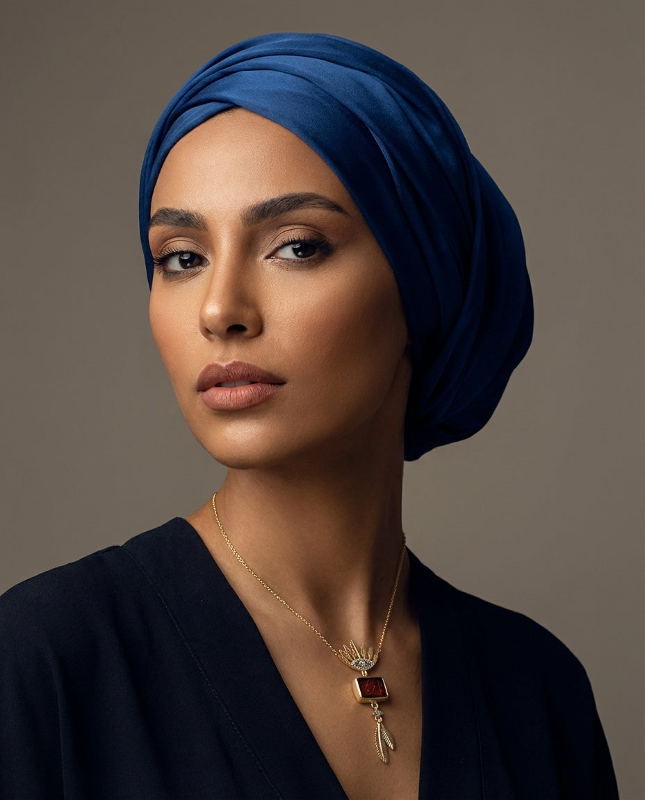 Woman wearing a blue headscarf with a Sterling Silver Hand Engraved Aqeeq 99 Names Necklace