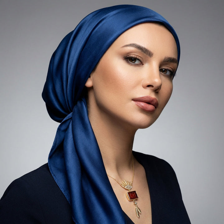 Woman wearing a blue headscarf and Sterling Silver Hand Engraved Aqeeq 99 Names Necklace on a gray background