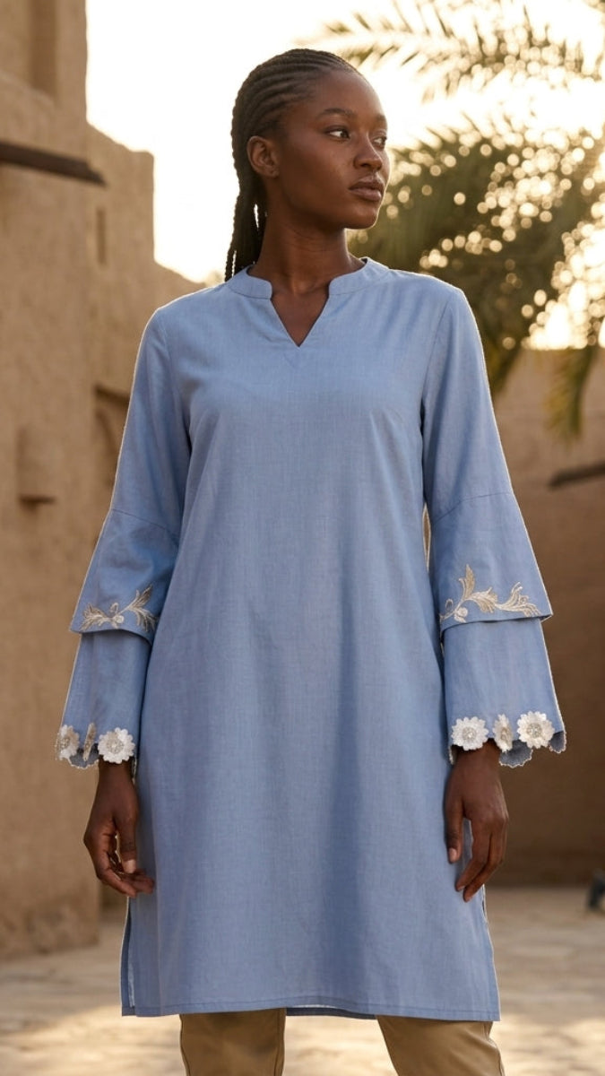 Woman wearing a blue dress with floral cuffs in a desert setting