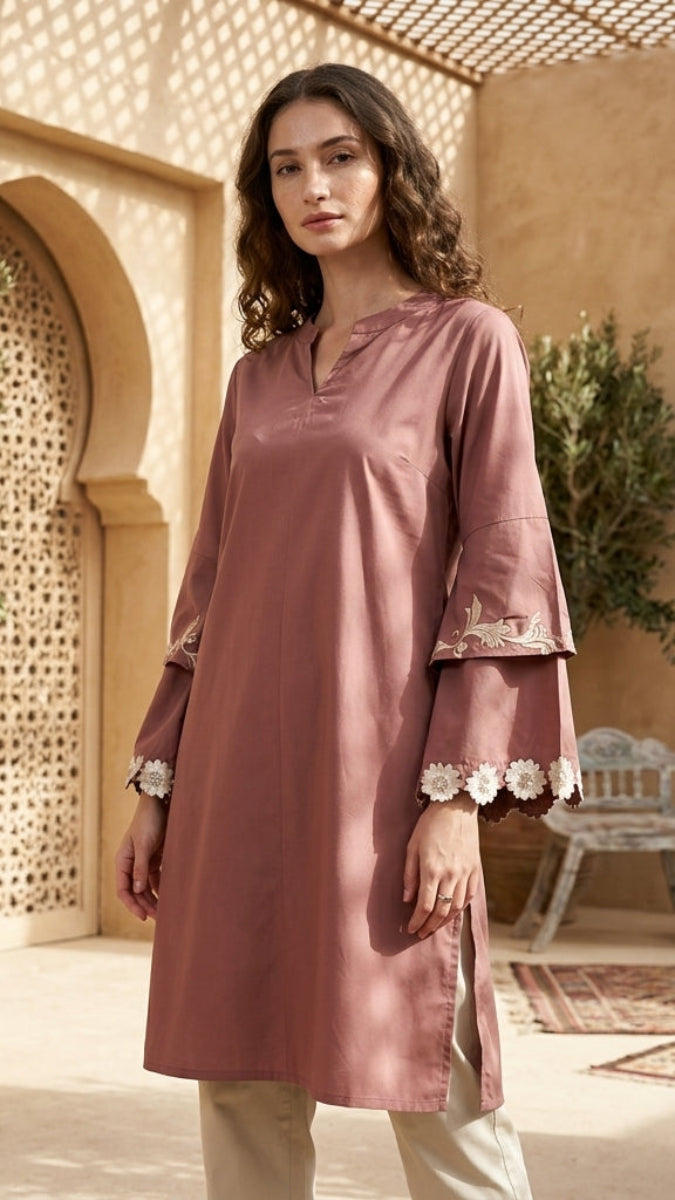 Woman wearing a pink traditional outfit in a decorative outdoor setting