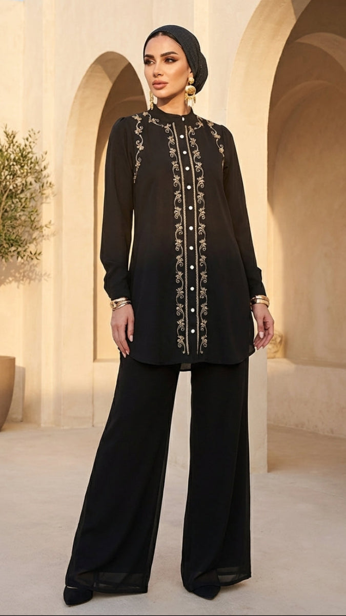Woman in a black outfit with intricate detailing standing in a sunlit archway.