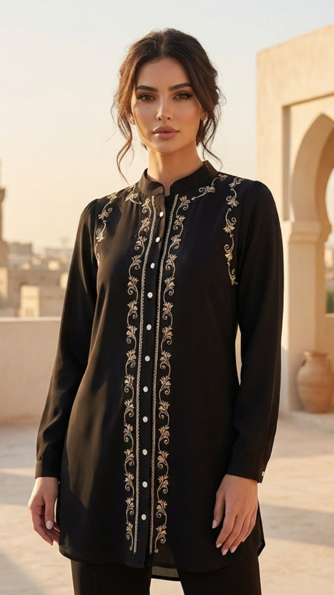 Woman wearing a black embroidered dress on a rooftop with architectural background