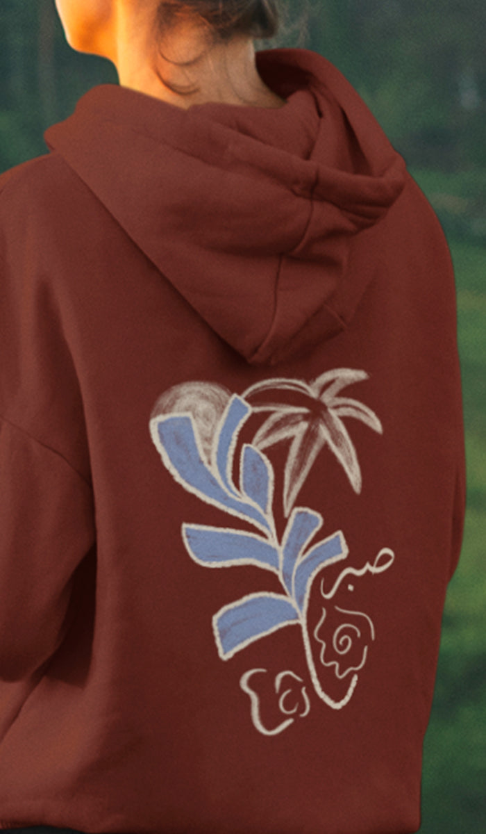 Brown hoodie with a decorative back design featuring blue and white elements.