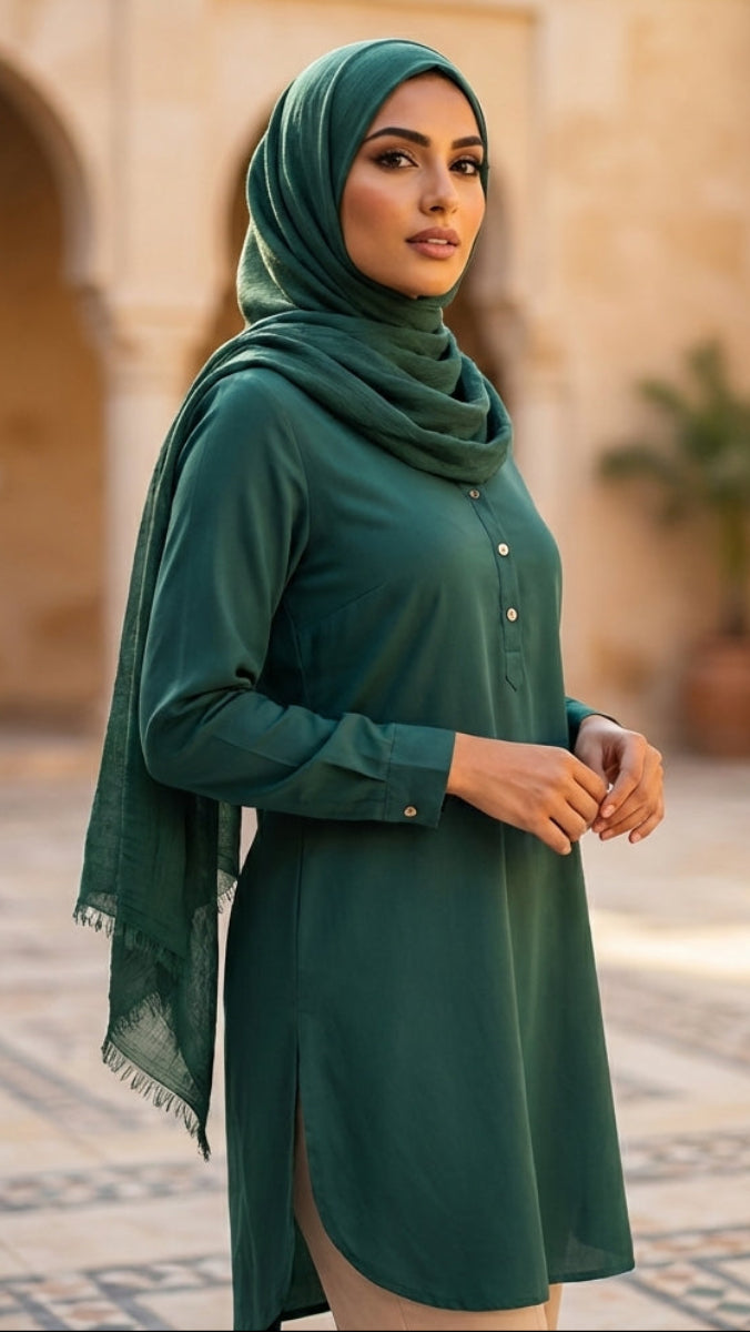Woman in a green outfit standing in an outdoor setting with architectural elements.
