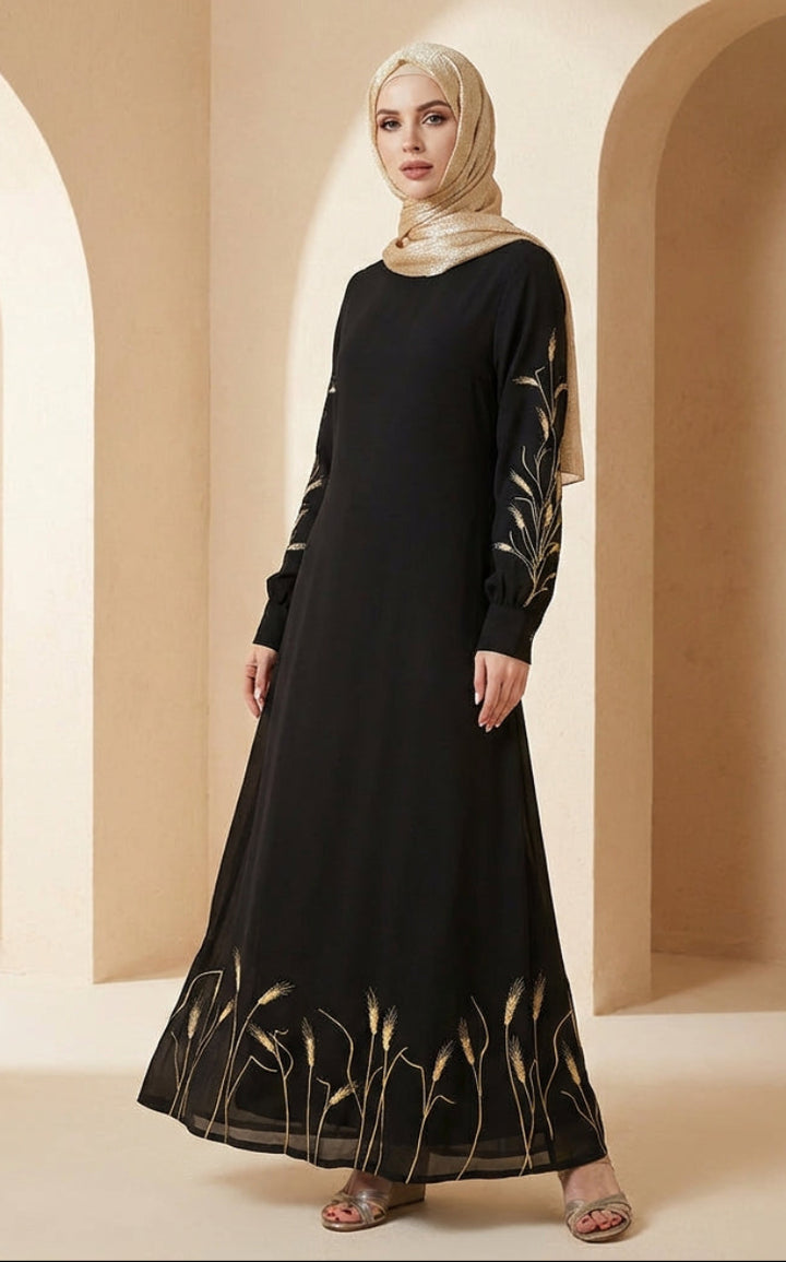 Woman wearing a black dress with gold embroidery in a beige archway setting