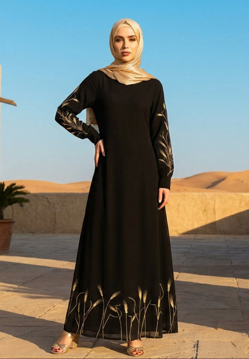 Woman in a black dress standing in a desert setting with architectural elements and plants.
