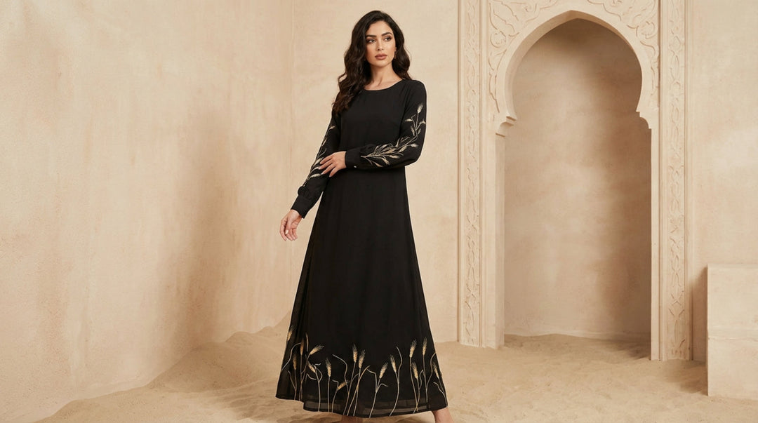 Woman wearing a black dress with intricate designs in a beige architectural setting