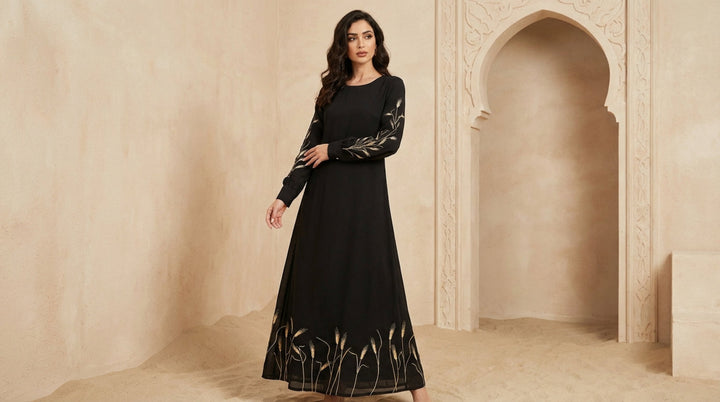 Woman wearing a black dress with intricate designs in a beige architectural setting