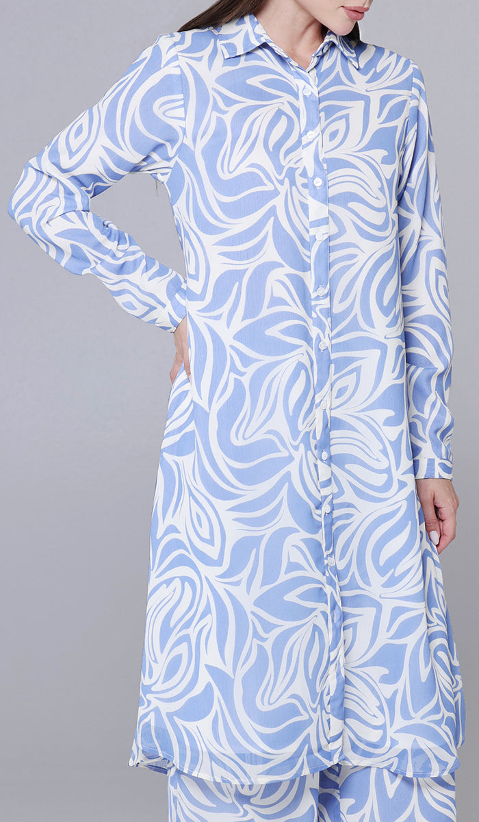 Woman wearing a blue and white patterned shirt dress on a gray background