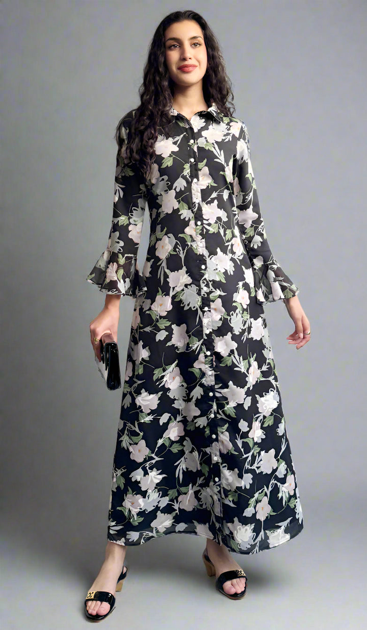 Woman wearing a floral dress standing against a plain background