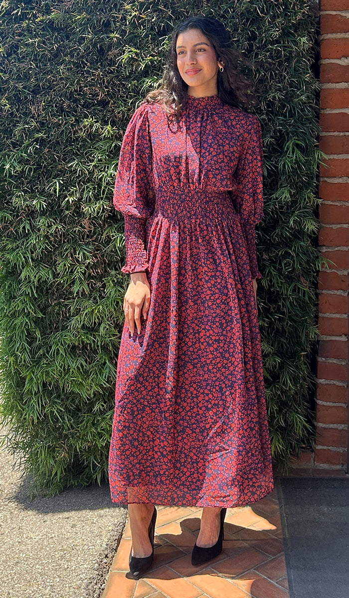 Woman outside wearing Anisa navy/red floral dress. 