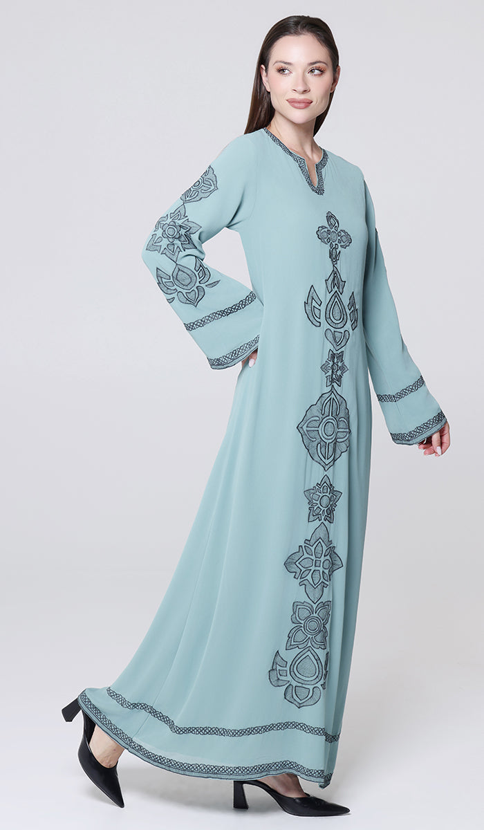 Woman wearing a light blue dress with intricate patterns on a white background