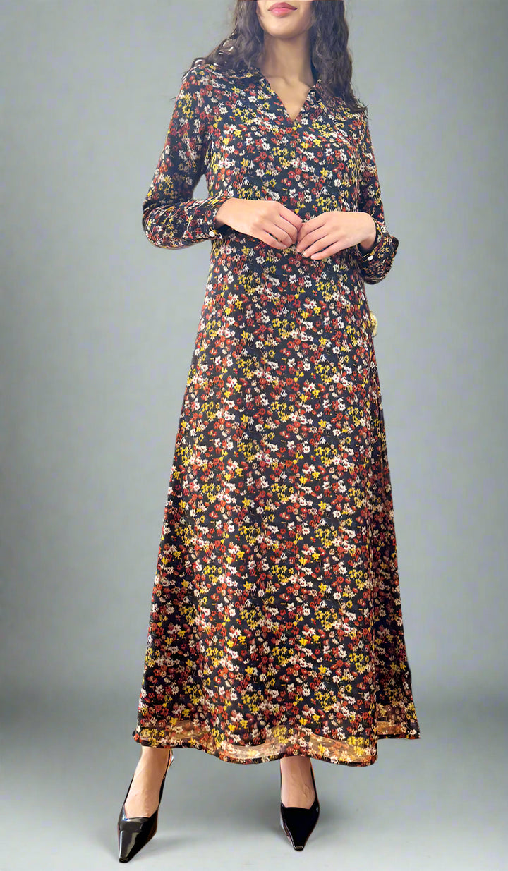 Woman wearing a floral dress standing in a room with a piano and a door leading outside.
