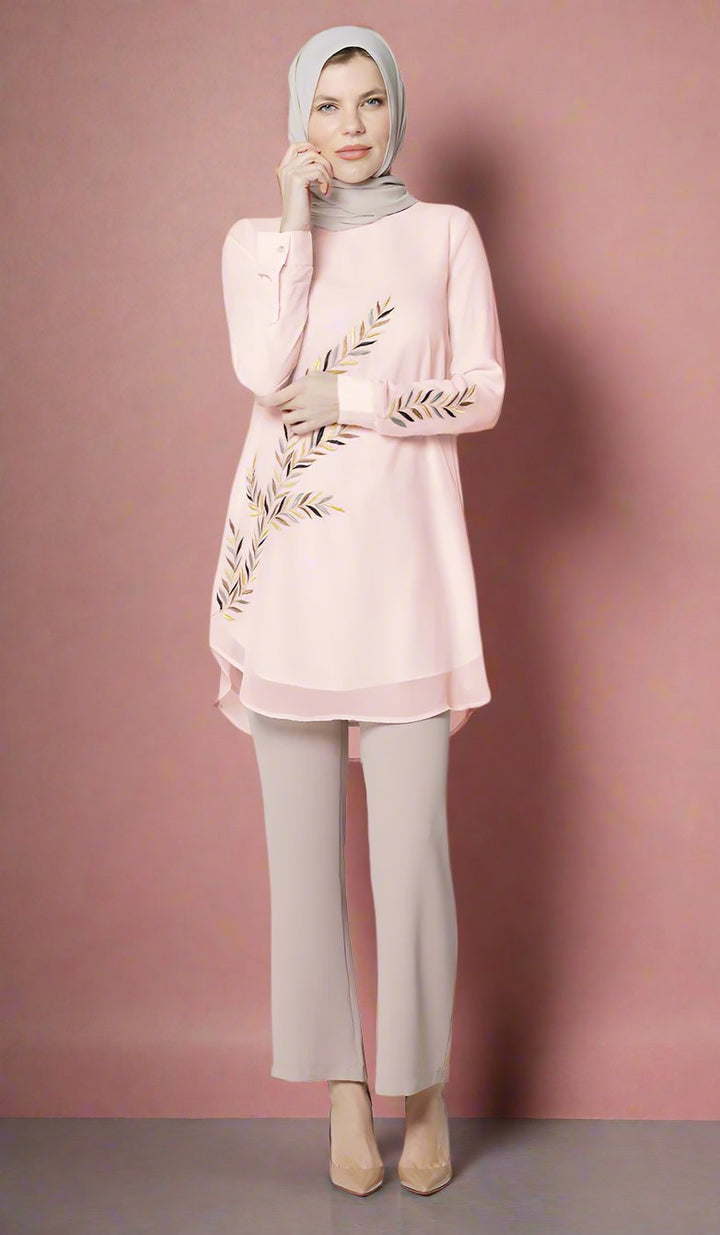 Woman wearing Baraka tunic in Blush Pink in front of pink wall.