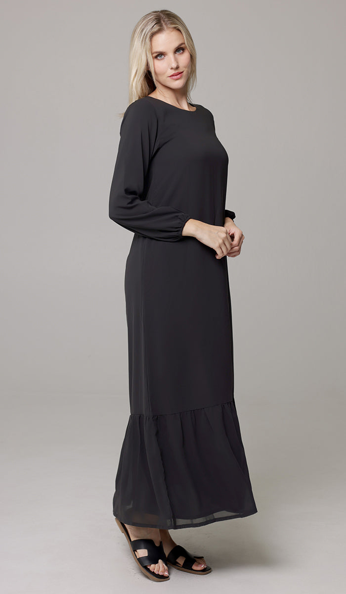 Side view of woman wearing Batool dress in Black. 