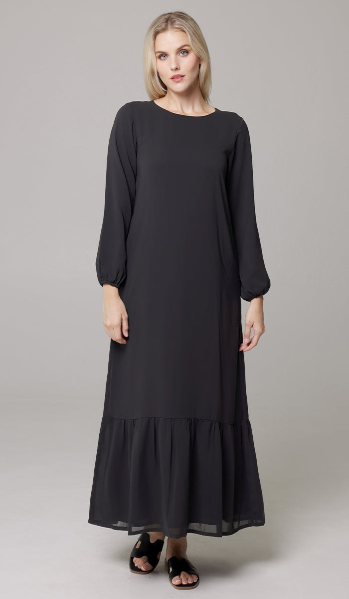 Woman wearing modest Batool dress in Black. 